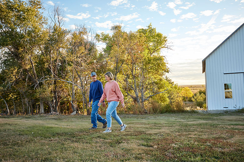 A farmer and his wife walk their rural property
